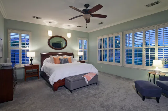 a spacious bedroom with a bed and a flat screen tv