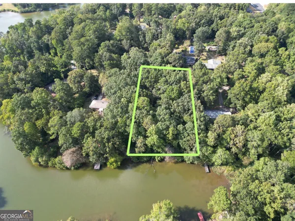 an aerial view of residential houses with outdoor space and trees