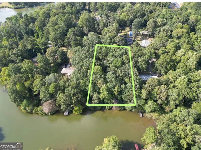an aerial view of residential houses with outdoor space and trees