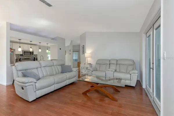 a living room with furniture and a wooden floor