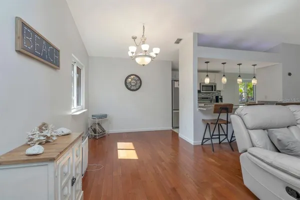 a view of a livingroom with furniture wooden floor and a chandelier