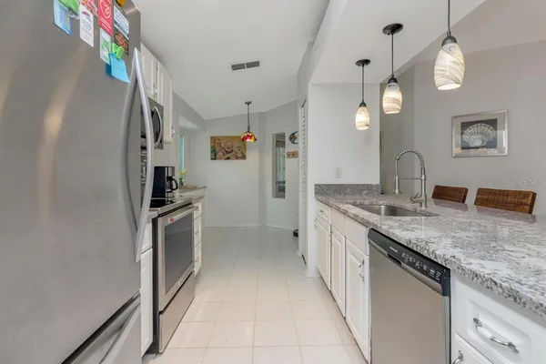 a kitchen with stainless steel appliances granite countertop a sink stove and refrigerator