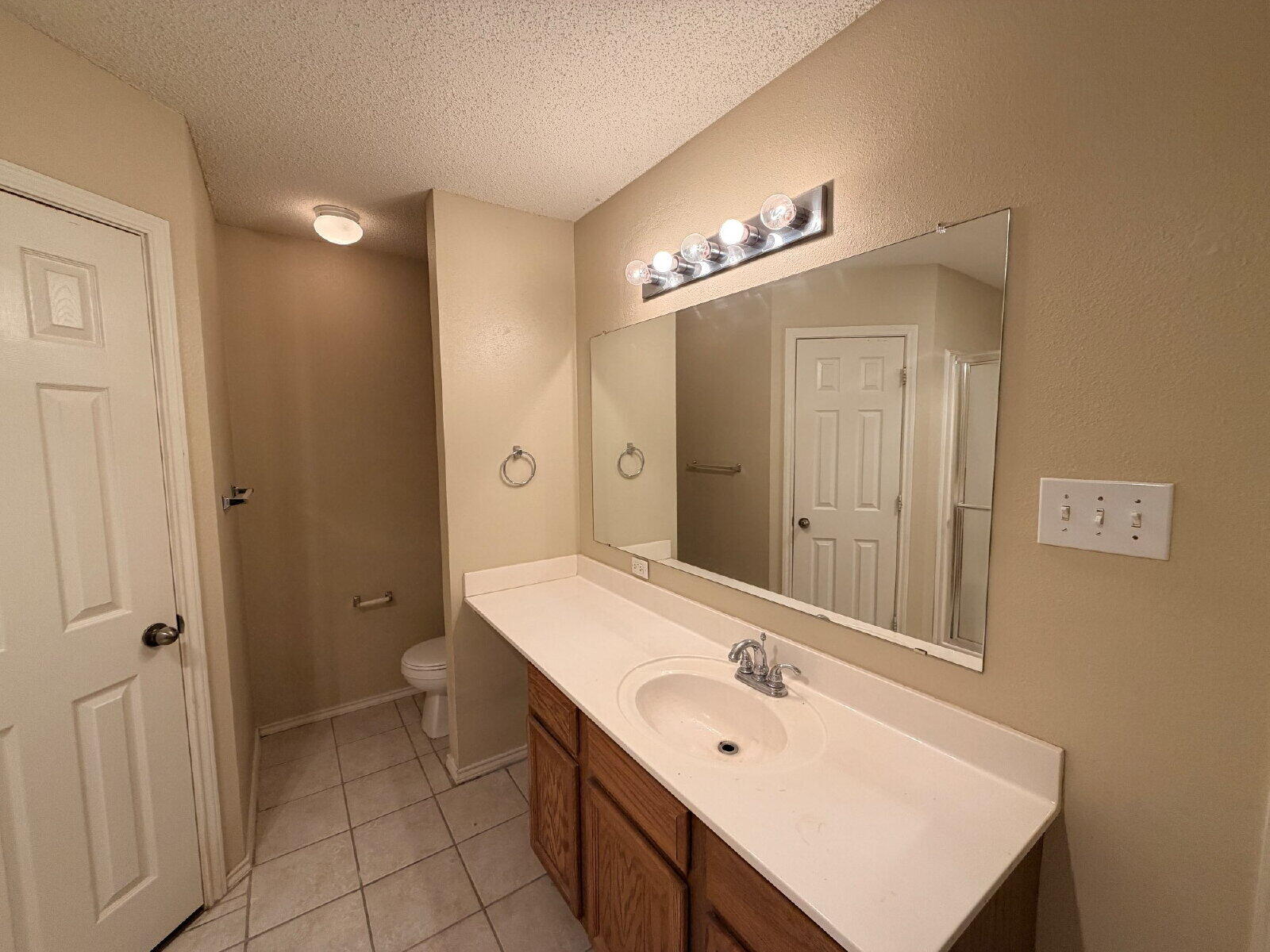 6126 16th Street Lubbock, TX 79416 - Photo 12 of 17 a bathroom with a sink a double vanity and a mirror
