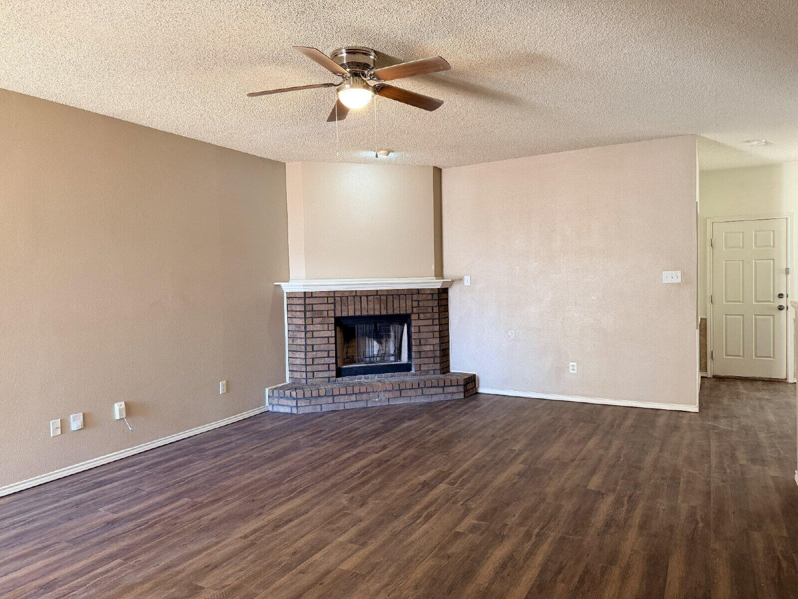 6126 16th Street Lubbock, TX 79416 - Photo 2 of 17 wooden floor in an empty room with a fireplace