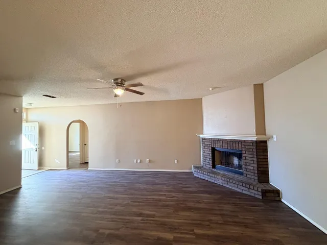 a view of empty room with wooden floor and fireplace
