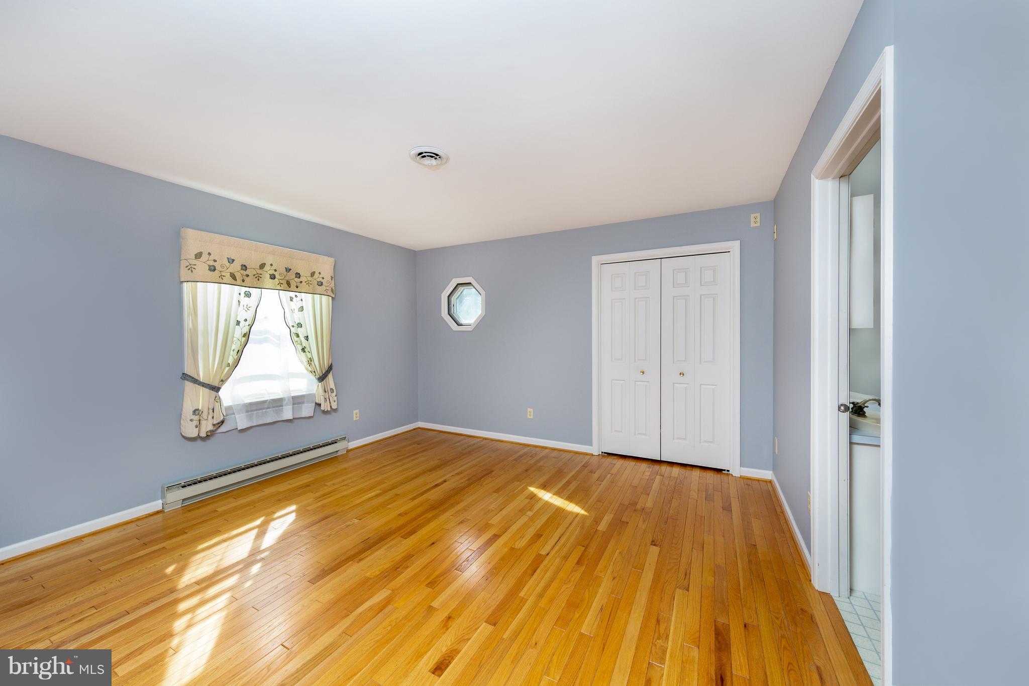 18257 Falls Road Hampstead, MD 21074 - Photo 13 of 49 a view of a bedroom with wooden floor and windows