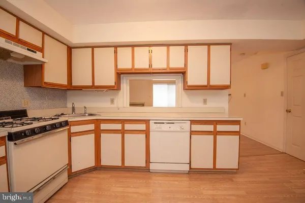 a kitchen with stainless steel appliances granite countertop a stove a sink and white cabinets