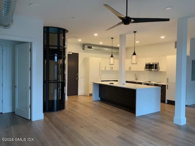 16 Old Track Road, Unit PH #3 Greenwich, CT 06830 - Photo 7 of 25 a large kitchen with a center island wooden floor stainless steel appliances and a window