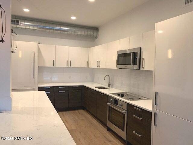 16 Old Track Road, Unit PH #3 Greenwich, CT 06830 - Photo 8 of 25 a kitchen with stainless steel appliances granite countertop a sink and white cabinets