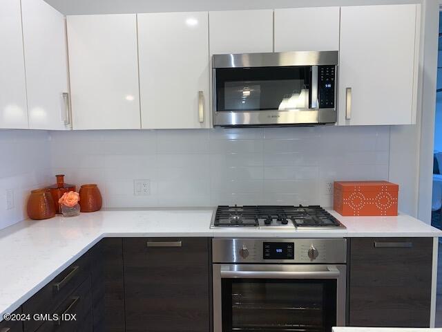 16 Old Track Road, Unit PH #3 Greenwich, CT 06830 - Photo 10 of 25 a kitchen with stainless steel appliances a stove and cabinets
