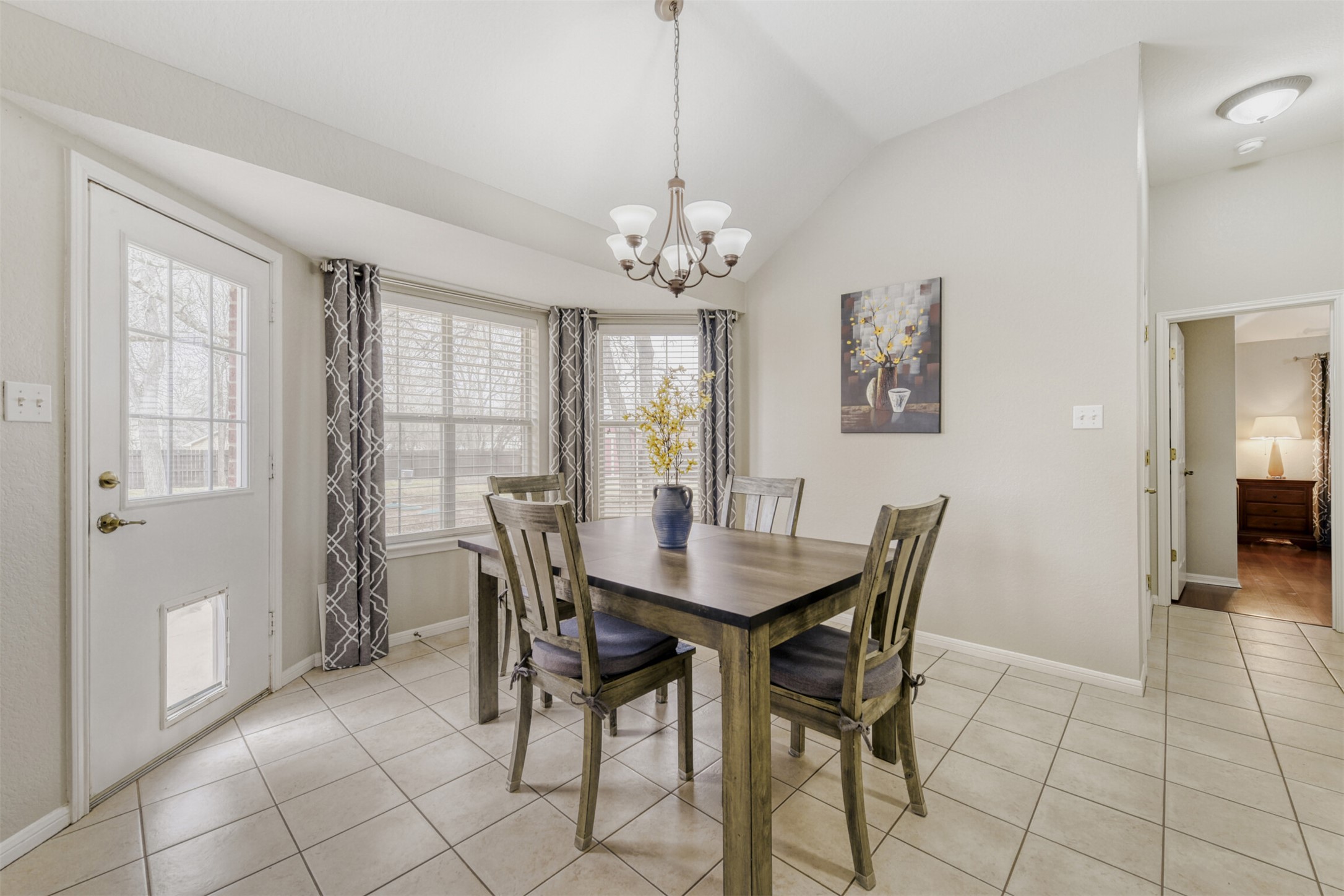 104 Spring Branch Bastrop, TX 78602 - Photo 15 of 32 Dining space with lofted ceiling, light tile patterned floors, and a chandelier