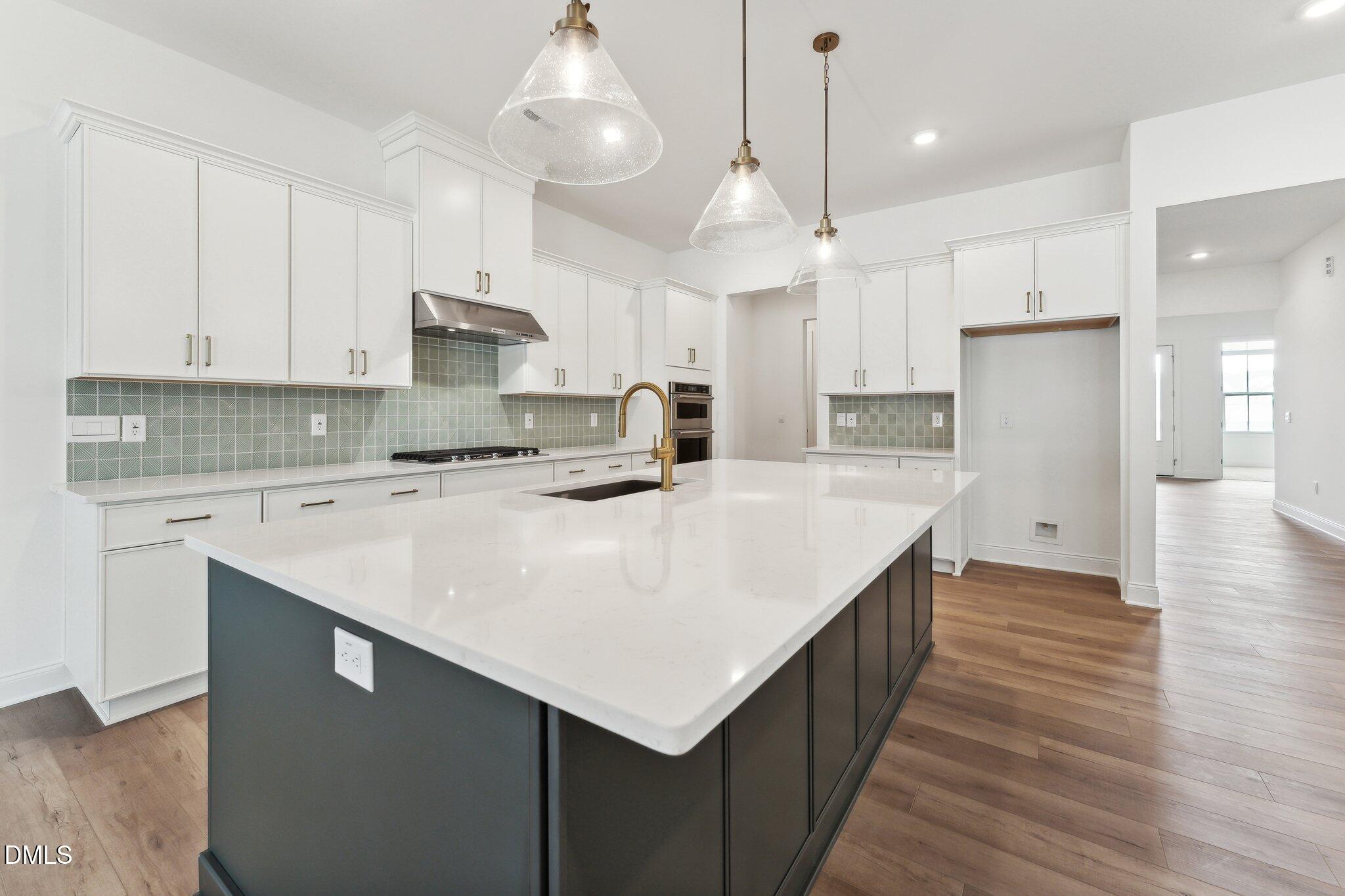 205 Mugby Road, Unit 173 Raleigh, NC 27610 - Photo 5 of 25 a kitchen with kitchen island a sink a center island stainless steel appliances and a center island