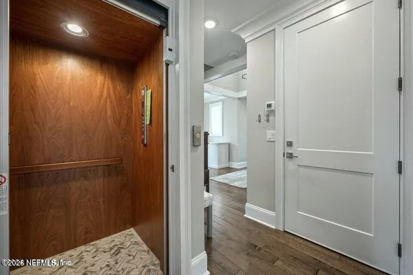 a view of a hallway with wooden floor and entryway
