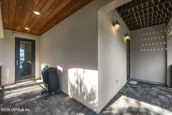 a view of a hallway with wooden floor and a bathroom