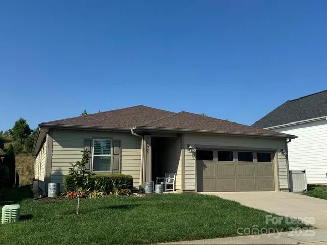 a front view of a house with a garden and yard
