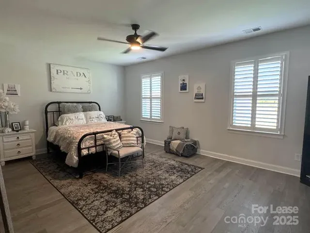 a spacious bedroom with a bed and a chandelier