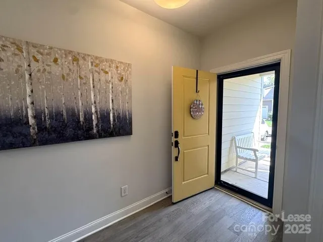 a kitchen with stainless steel appliances granite countertop a stove top oven a sink a dining table and chairs with wooden floor