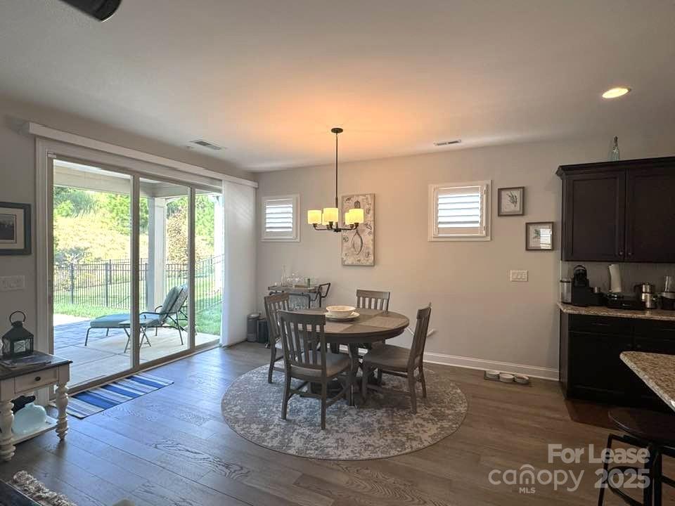 4995 Looking Glass Trail Denver, NC 28037 - Photo 10 of 32 a dining room with wooden floor a chandelier a wooden table and chairs