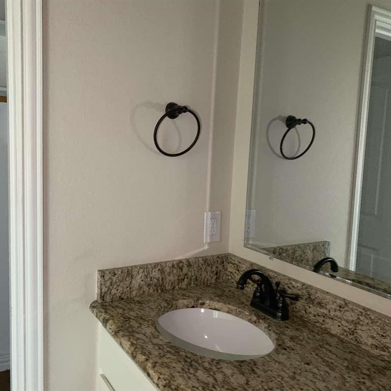 409 Maple Row Denison, TX 75021 - Photo 13 of 19 a bathroom with a granite countertop sink and a mirror