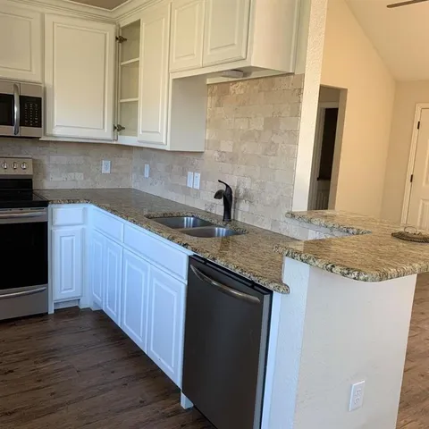a kitchen with stainless steel appliances granite countertop a sink and cabinets