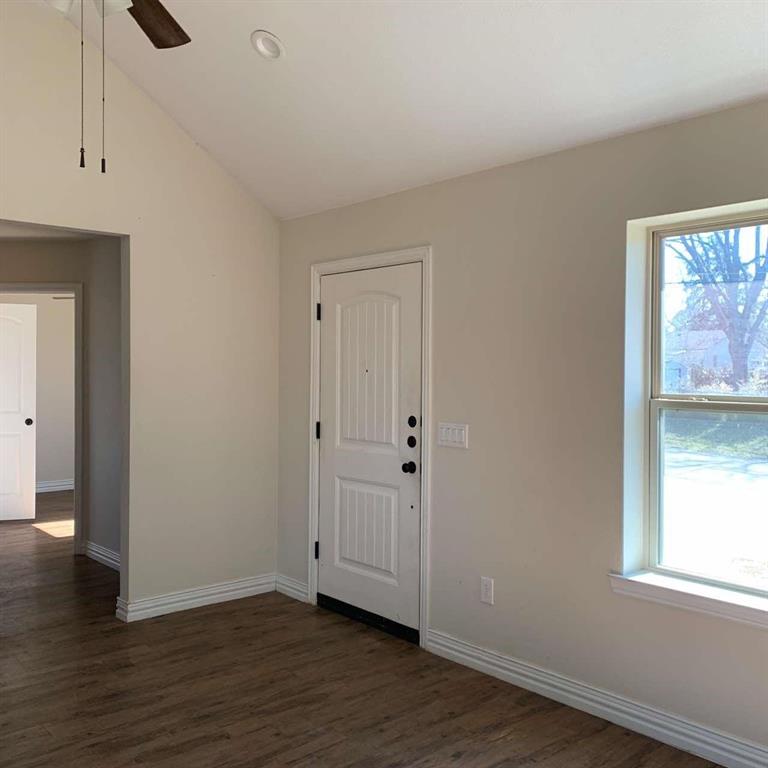 409 Maple Row Denison, TX 75021 - Photo 4 of 19 a view of an empty room with wooden floor and a window