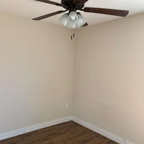 a view of a room with wooden floor and fan