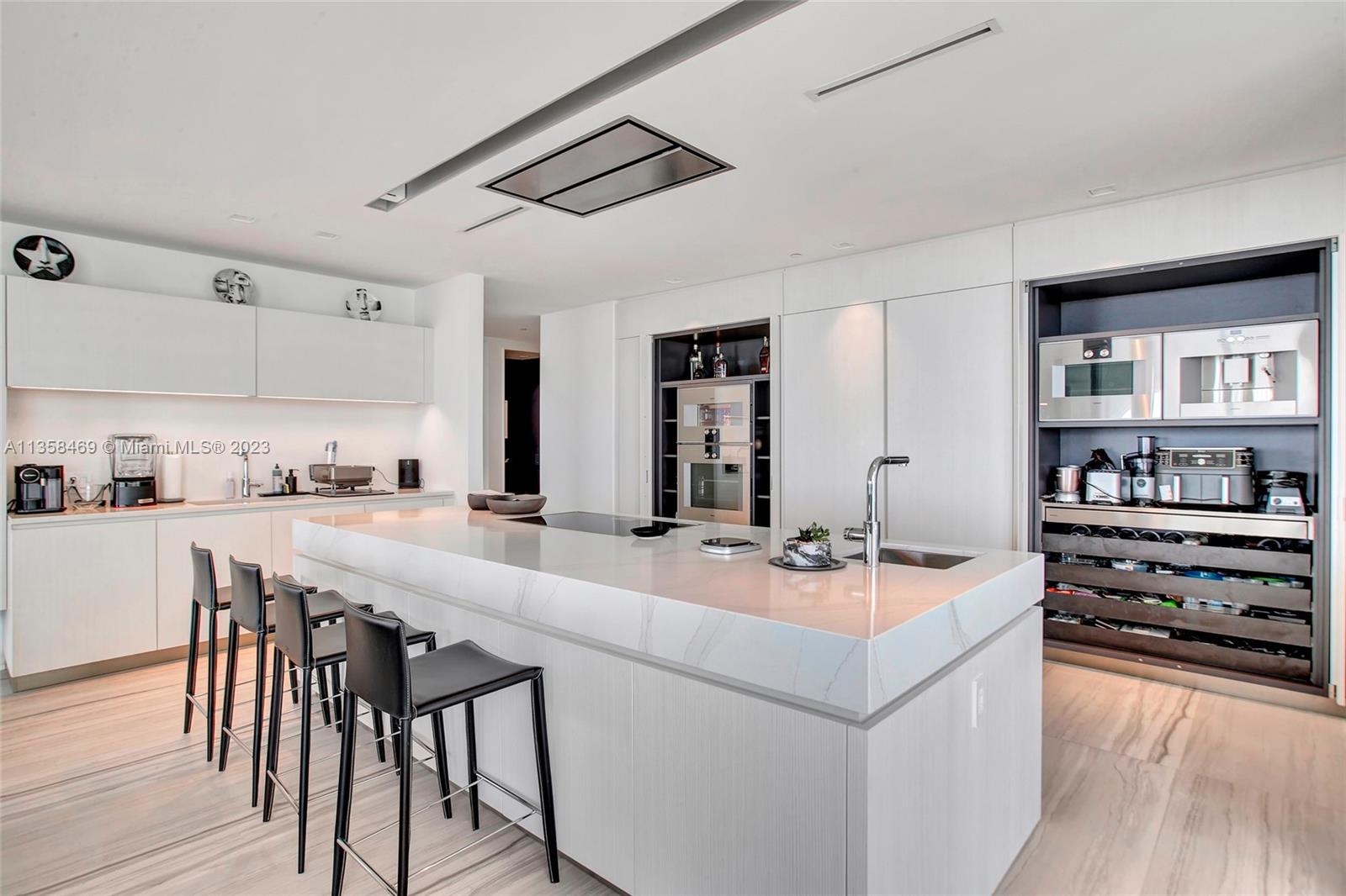 1000 Biscayne Boulevard, Unit 2802 Miami, FL 33132 - Photo 12 of 38 a kitchen with stainless steel appliances a stove a sink and white cabinets with wooden floor