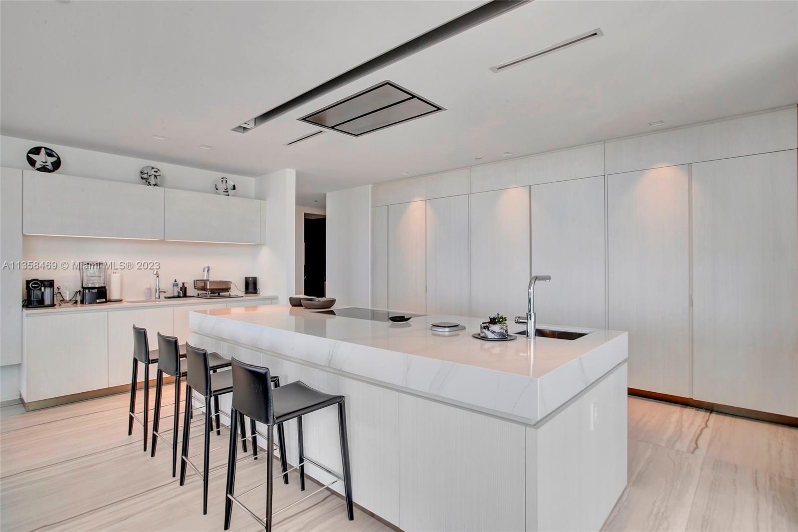 1000 Biscayne Boulevard, Unit 2802 Miami, FL 33132 - Photo 13 of 38 a kitchen with a sink a stove a refrigerator and white cabinets with wooden floor