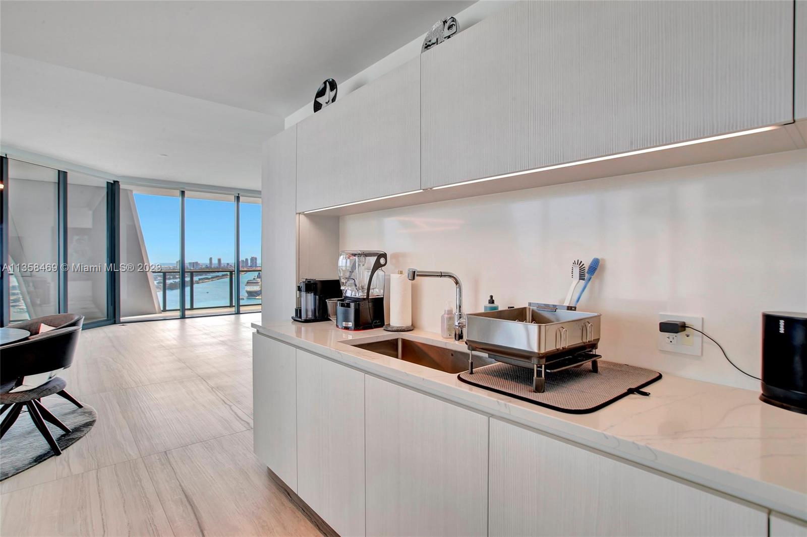 1000 Biscayne Boulevard, Unit 2802 Miami, FL 33132 - Photo 15 of 38 a kitchen with kitchen island a sink stove and wooden floor