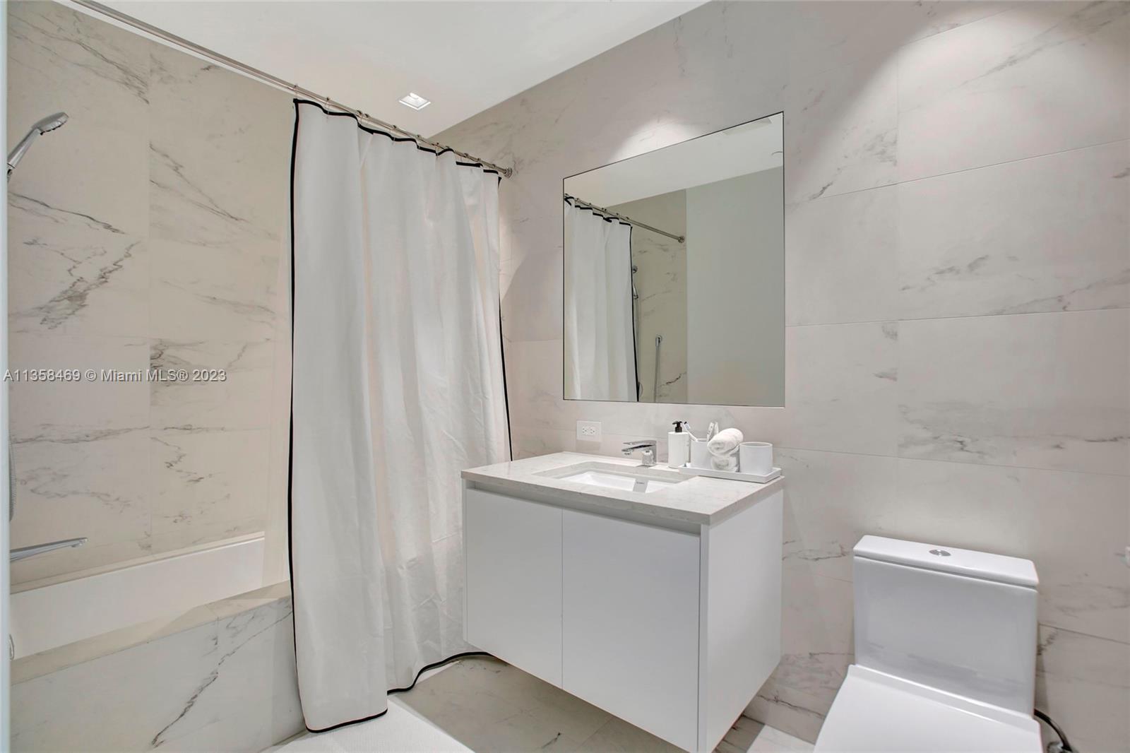 1000 Biscayne Boulevard, Unit 2802 Miami, FL 33132 - Photo 27 of 38 a bathroom with a sink a toilet and shower