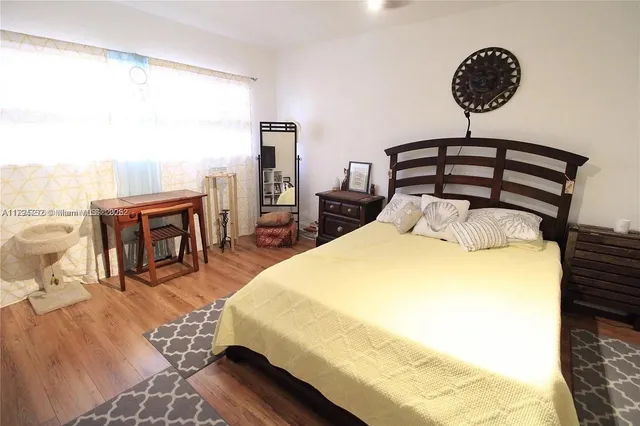 a bedroom with a bed a mirror and lamp on desk