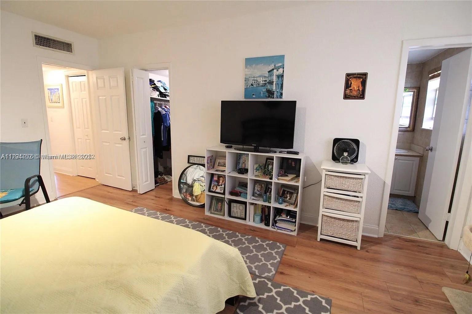 9260 Bay Harbor Terrace, Unit 22 Bay Harbor Islands, FL 33154 - Photo 15 of 24 a bedroom with a bed and a flat screen tv