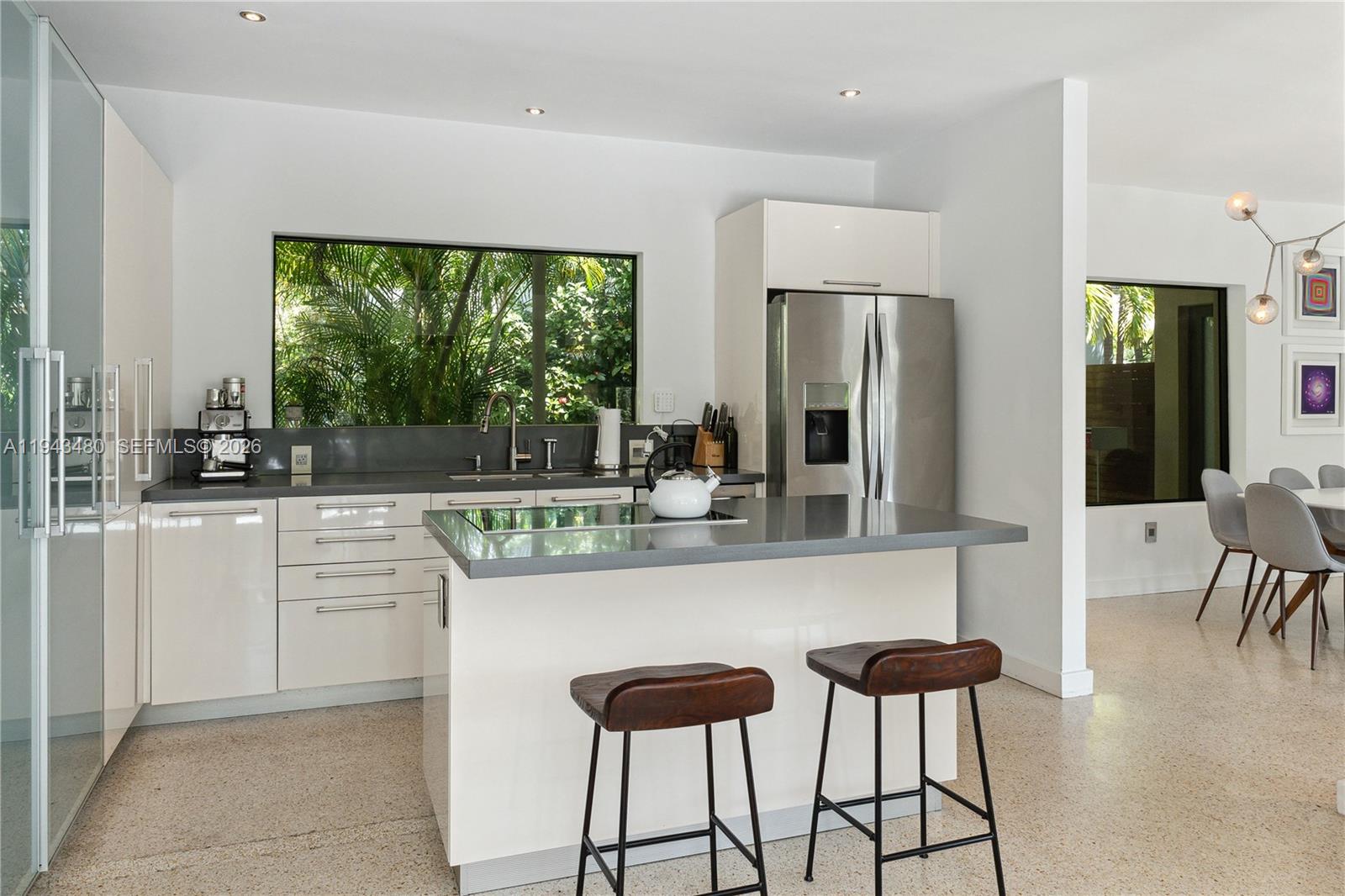 12901 Oleander Road North Miami, FL 33181 - Photo 12 of 30 a kitchen with stainless steel appliances a dining table chairs and a large window