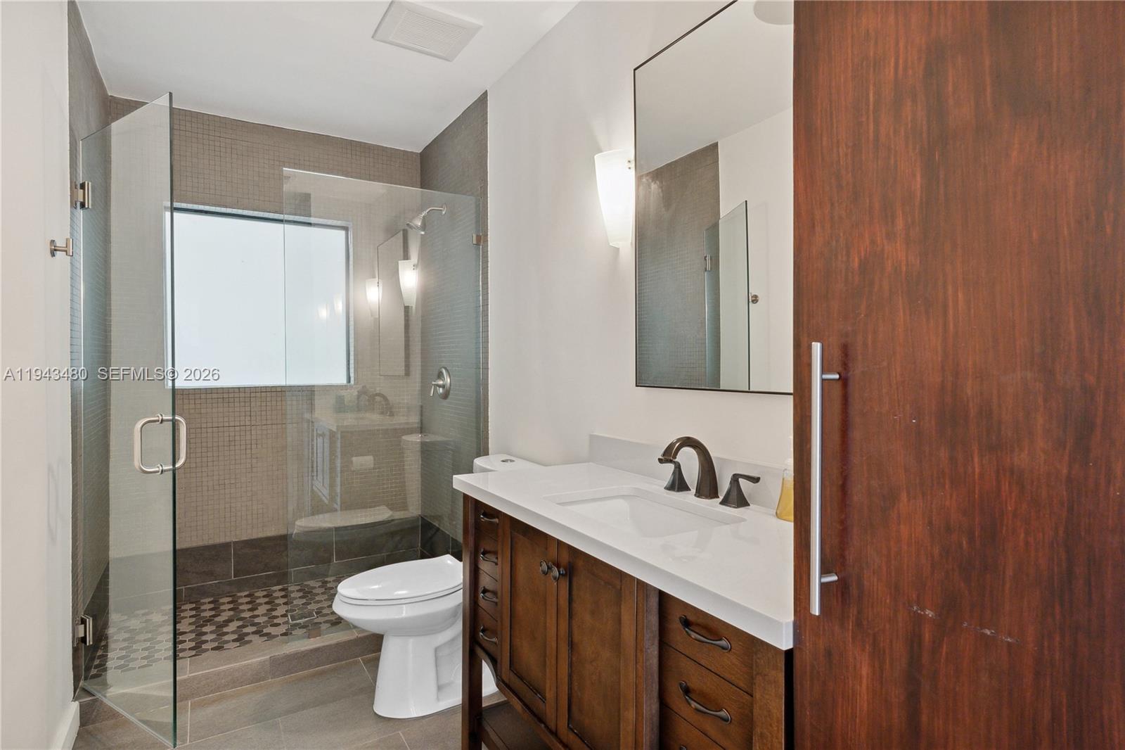 12901 Oleander Road North Miami, FL 33181 - Photo 24 of 30 a bathroom with a sink toilet a mirror and shower