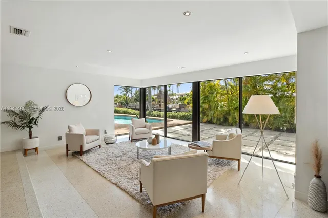 a kitchen with stainless steel appliances a dining table chairs and a large window
