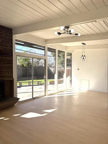 a view of a room with a floor to ceiling window and wooden fence