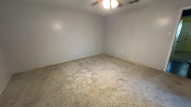an empty room with a chandelier fan