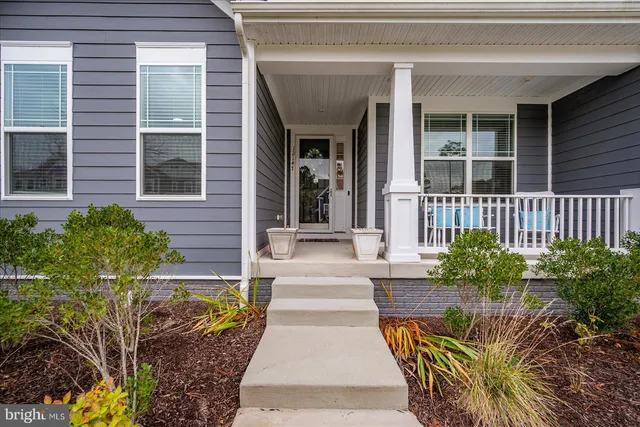 a view of a hallway with wooden floor and a living room