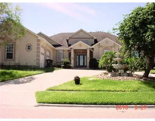 a view of a white house with a big yard and large trees
