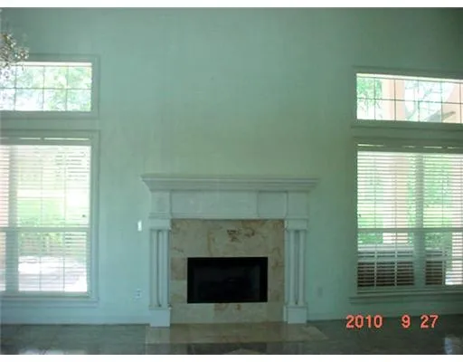 a living room with a fireplace and windows
