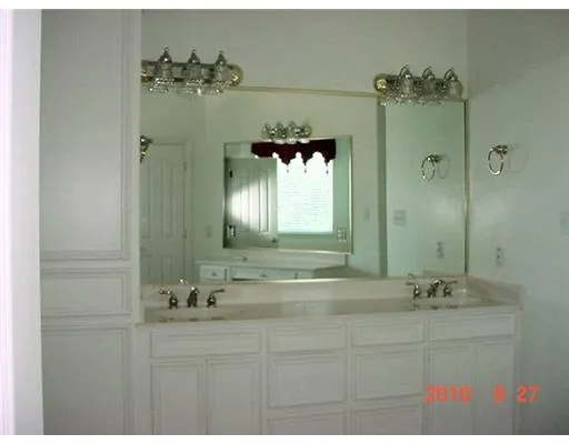 a bathroom with a sink and mirror with shower