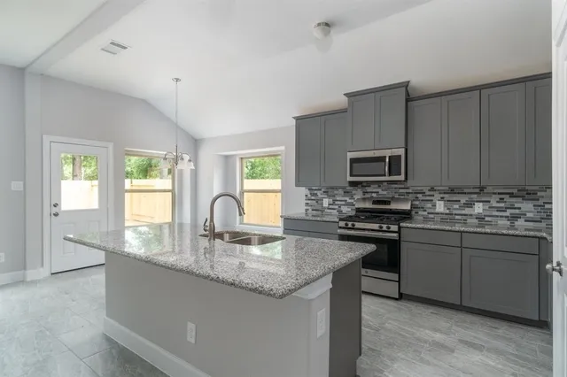 a kitchen with stainless steel appliances granite countertop microwave stove top oven and cabinets