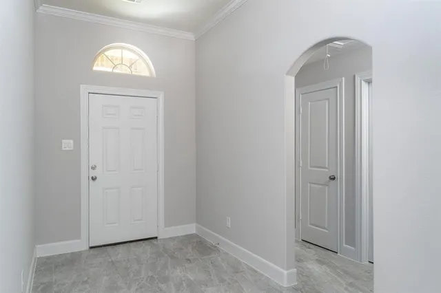 a large white kitchen with granite countertop a large window and white appliances