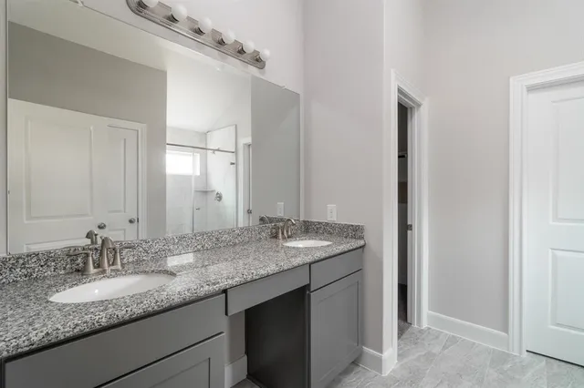 a bathroom with a granite countertop sink and a mirror