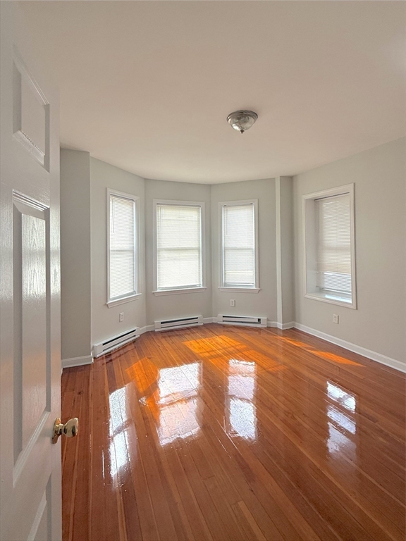 20 Huss Court, Unit 105 Lynn, MA 01905 - Photo 11 of 16 an empty room with wooden floor and windows