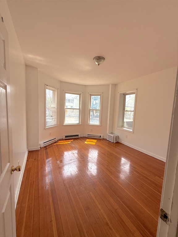 20 Huss Court, Unit 105 Lynn, MA 01905 - Photo 3 of 16 an empty room with wooden floor and windows