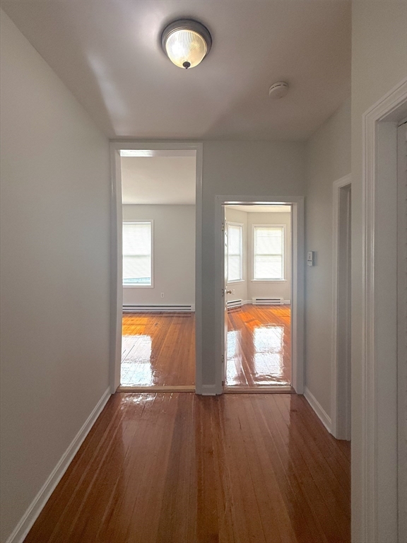 20 Huss Court, Unit 105 Lynn, MA 01905 - Photo 9 of 16 an empty room with wooden floor and windows