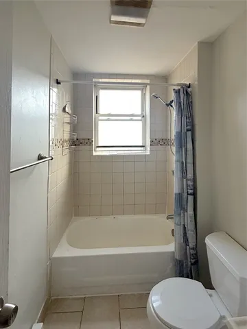 a bathroom with a bathtub toilet and shower