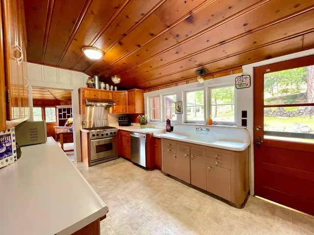a large kitchen with stainless steel appliances wooden floors and large windows