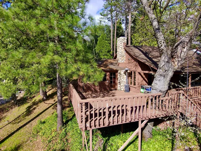 a view of a roof deck with wooden fence and a bench